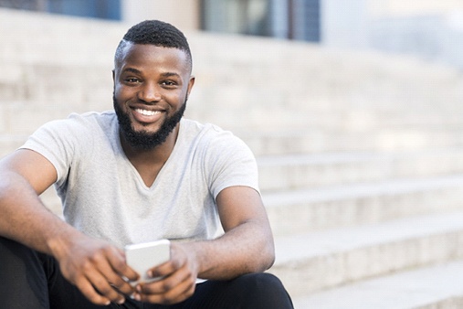 person sitting on stairs and smiling