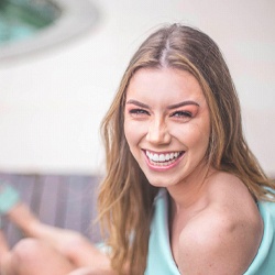 Young woman by pool smiling