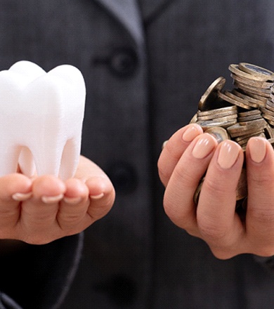 Molar and coins in palm of hands