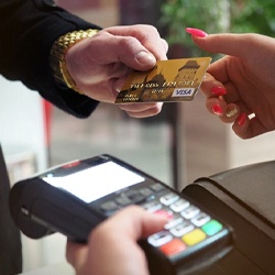 Man handing woman credit card for payment