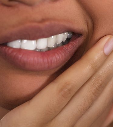 Close-up of a woman rubbing her jaw