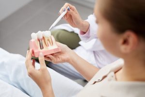 dentist showing patient a diagram of dental implants in norwalk