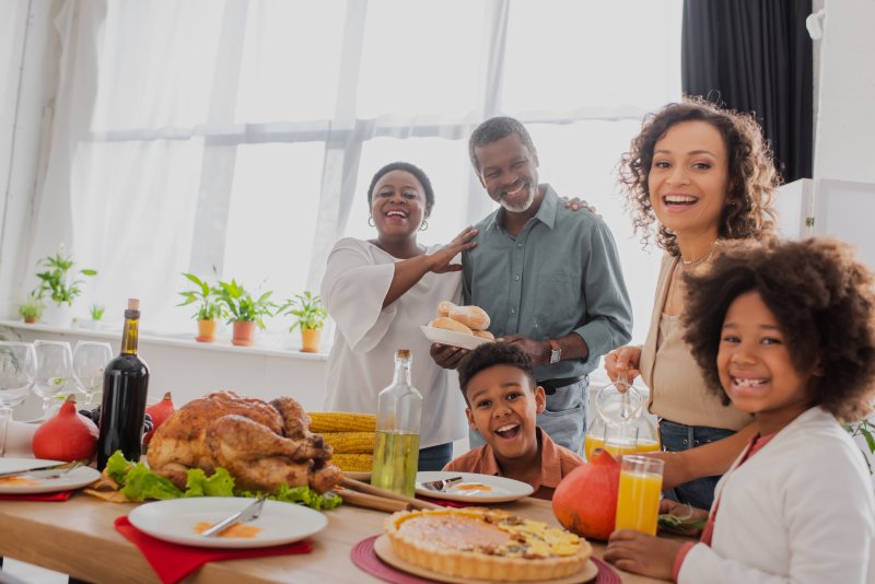 A family enjoying a holiday meal while celebrating their dental health
