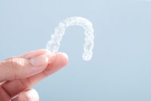 woman holding clear correct braces