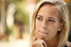 young woman thinking before giving in to bad dental habits